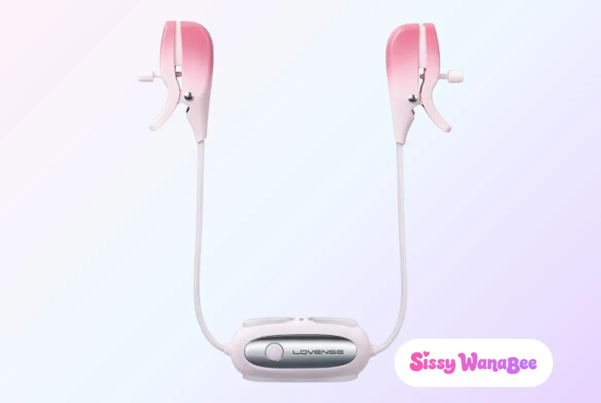Studio product shot of the Lovense Gemini vibrating nipple clamps in blush pink silicone against a soft pink and lavender gradient, the two clamps hanging open on their white tension screws, slim white cables curving down to meet at the silver-faced Lovense control module, the quiet anticipation of an evening ritual