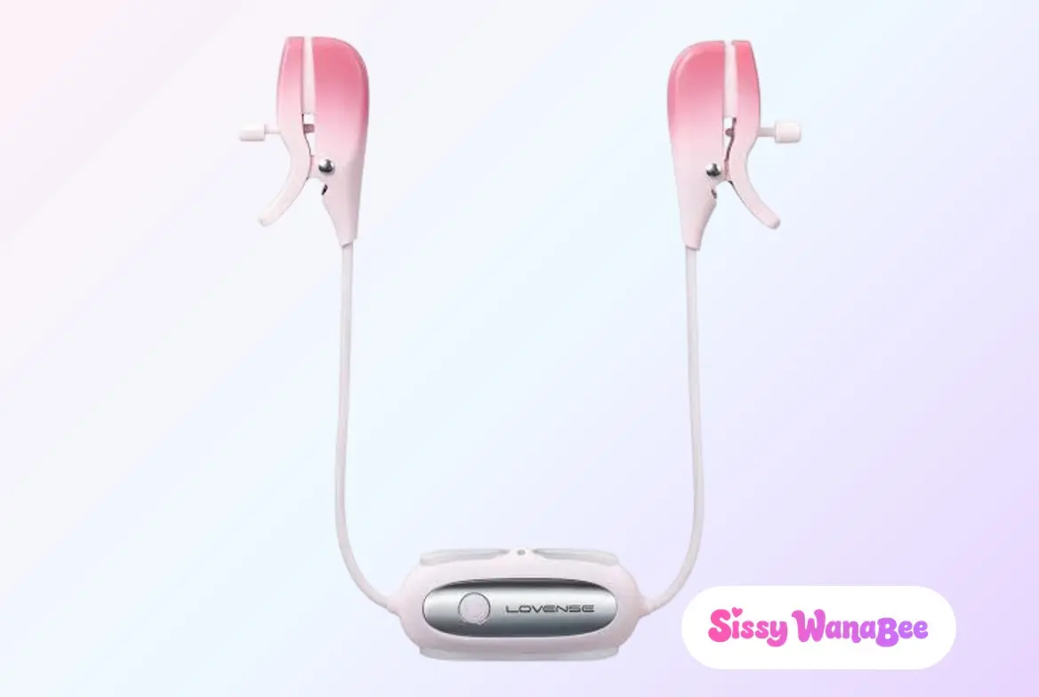Studio product shot of the Lovense Gemini vibrating nipple clamps in blush pink silicone against a soft pink and lavender gradient, the two clamps hanging open on their white tension screws, slim white cables curving down to meet at the silver-faced Lovense control module, the quiet anticipation of an evening ritual