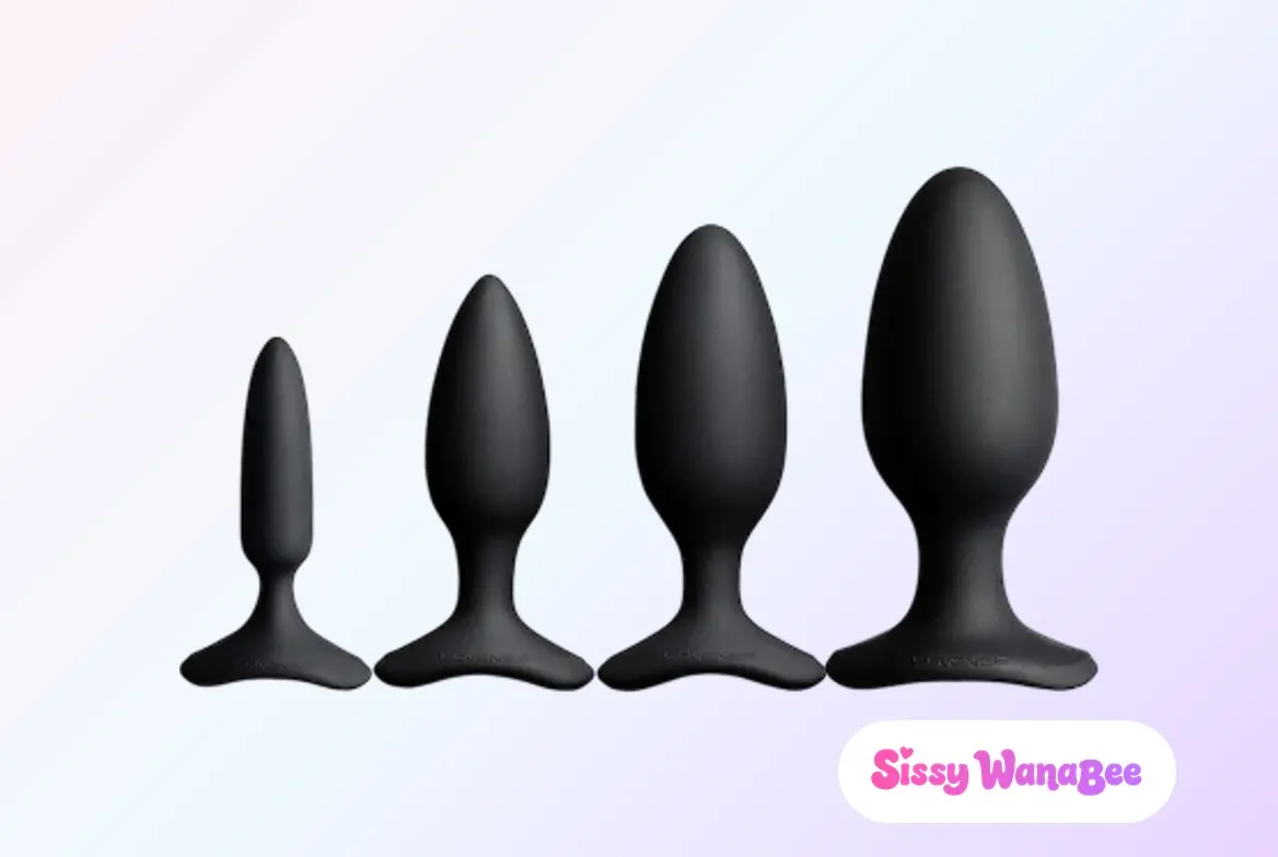 Studio product shot of the four Lovense Hush 2 vibrating plugs in matte black silicone standing in a row smallest to largest against a soft pink and lavender gradient, each tapered bulb narrowing to a slim neck above a flared T-base, the quiet calm of a range chosen to be worn all day